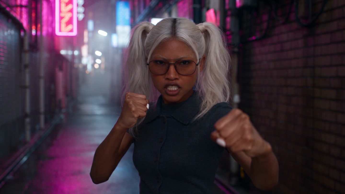 Nima Sterling with platinum ponytails and glasses in pink and blue neon light